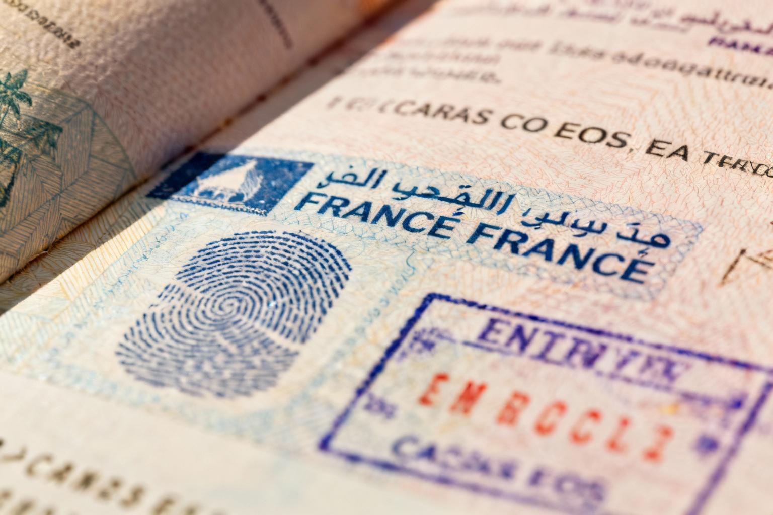 Passeport français ouvert montrant des tampons de visa marocain et le symbole biométrique, éclairage naturel