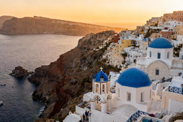Village traditionnel blanc de Santorin avec dômes bleus, vue sur la mer Égée au coucher du soleil