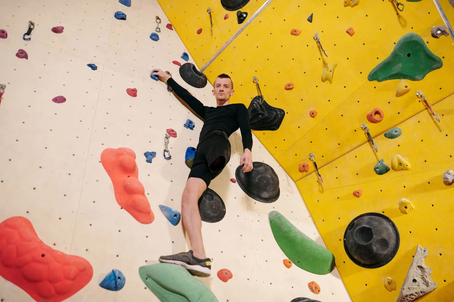 Grimpeur sur un mur d'escalade en salle
